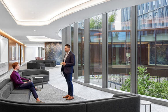 two people talk in a hallway overlooking a circular courtyard