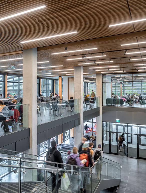 View down the main stairs to the entry from the second floor of the servery with students.